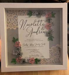 a white frame with flowers on it and the words'wedding & anniversary'written in cursive writing