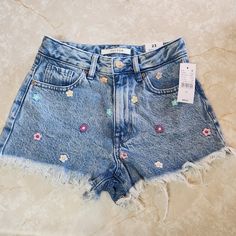 a pair of jean shorts with flowers on them