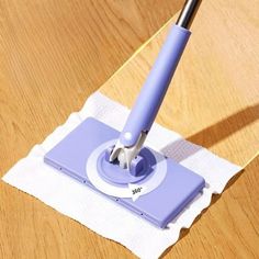 a blue and white mop sitting on top of a wooden table next to a paper towel