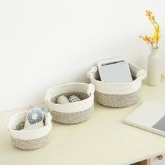 there are three baskets on the table with an electronic device in them