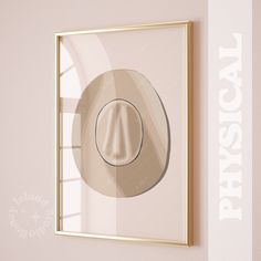 a gold frame hanging on the wall above a light pink wall with a round button