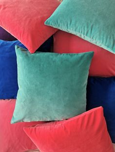 several different colored pillows stacked on top of each other