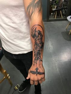 a man with a tattoo on his arm is holding the hand of another person in front of him