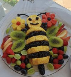 a plate topped with fruit shaped like a bee