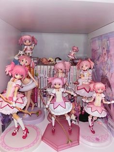 a group of figurines sitting on top of a table next to bookshelves