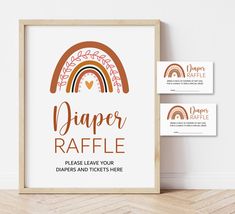 a framed sign and business cards for diaper raffle on a wooden floor next to a white wall