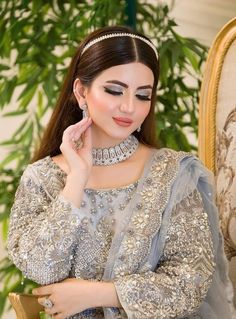 a woman wearing a tiara sitting on a chair