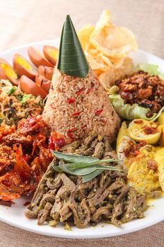 a white plate topped with lots of different types of food on top of a table