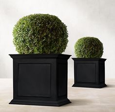 two black planters sitting on top of a table