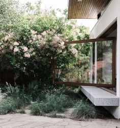 an outdoor area with stone steps and plants on the side of the house, surrounded by greenery