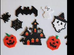 halloween decorations made out of perler beads on a white surface with black and orange pumpkins