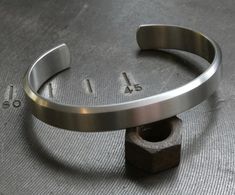 Sturdy handcrafted grade 2 titanium satin brushed finished bracelet 10 mm in width and 2,5 mm thick. For wrist with circumference of approximately 18 tot 18,50 cm measured over the bony knuckle just on. You can bend or stretch the bracelet a little to adjust size. We can make different sizes just let us know. Comes in a gift box. Mens Cuff Bracelets, Braided Rope Bracelet, Industrial Jewelry, Stackable Bangles, Viking Bracelet, Titanium Bracelet, Titanium Jewelry, Cuff Bangle Bracelet, Handmade Bangles