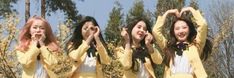 four girls in yellow jackets are posing for the camera