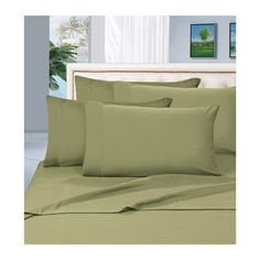 a bed with green sheets and pillows on it