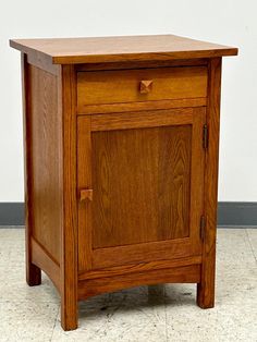 a wooden cabinet sitting on top of a tiled floor