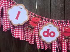 a red and white gingham banner with an i do sign hanging from it