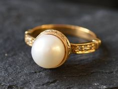 Gold Pearl Ring set with a Natural Pearl, AAA grade (stands for roundness, luster & color), at 10mm diameter, sourced from Japan. Crown Ring design with Hidden Halo made of Gold Vermeil ☞ thickest 18k Gold Plating on top of Solid 925 Sterling Silver ☞ made to last. Matching Earrings - please ask meMatching Pendant - please ask me Details:• Natural Pearl sourced from Japan & CZ Diamonds• Pearl: 10mm AAA Grade• Band width ≈ 2.9mm, thickness ≈ 1.7mm• 18K Gold Vermeil❀ Each Natural Gem is unique & w Dome Ring With Prong Setting As Gift, Formal Pearl Ring With Bezel Setting, Anniversary Cabochon Pearl Ring, Pearl Rings Vintage, White Pearl Ring, Gold Pearl Ring, Mother Rings, Crown Ring, Hidden Halo