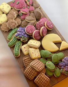 a wooden cutting board topped with lots of different types of cookies