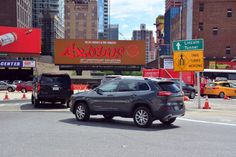 cars are driving down the street in front of large billboards with advertisements on them