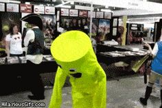 a blurry image of people walking through a store with neon green clothing and headgear