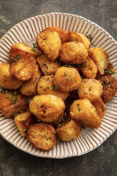 a white plate topped with fried potatoes on top of a table