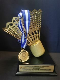 a gold trophy with a blue ribbon around it