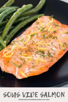 salmon and green beans on a black plate with the words sous - vide salmon