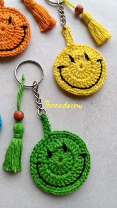 crocheted smiley face keychains with tassels on them are shown