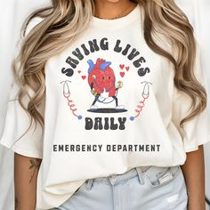 Show your dedication with our "Saving Lives Daily" ER Nurse Tee. Perfect for emergency department professionals, this shirt is ideal for ED nurses, trauma nurses, and ER techs. Celebrate your role in emergency medicine with this comfortable and stylish department shirt. Whether you're an ER RN or part of the emergency team, this tee showcases your commitment to saving lives daily. Add this essential ER nurse shirt to your wardrobe today! Er Tech, Ed Nurse, Er Nurse, Emergency Medicine, Emergency Department, Nurse Shirt, Nursing Shirts, Saving Lives, San Jose