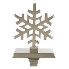 a silver snowflake on a metal stand with white backgrounnds