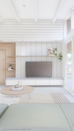 a living room filled with furniture and a flat screen tv on top of a wooden table