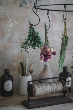 some flowers are hanging from a rack on a table