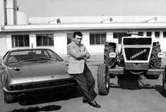 a man standing next to a tractor in front of a building