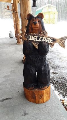 a bear statue holding a sign that says welcome