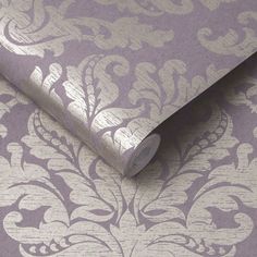 a purple and silver wallpaper with an ornate design on it's surface,