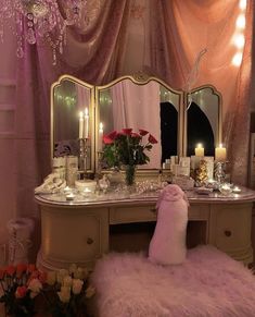 a dressing table with candles and flowers on it