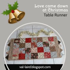 a table runner with a christmas theme on it and a bell hanging from the top