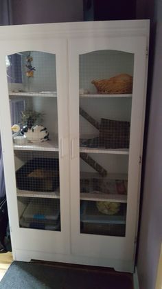 a white cabinet with glass doors and shelves