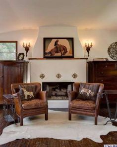 a living room filled with furniture and a fire place under a painting on the wall