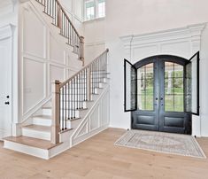 an entryway with two doors and a stair case