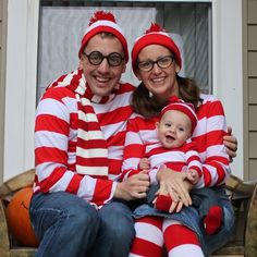 a man and woman in matching red and white striped outfits are sitting on a porch with their baby