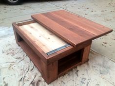 a coffee table made out of pallet wood on the ground next to a car