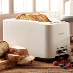 a loaf of bread sitting on top of a wooden cutting board next to sliced bread