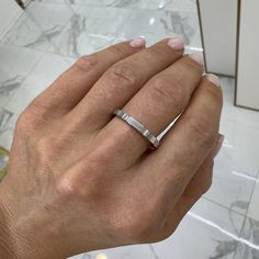 a woman's hand with a diamond ring on her left wrist, in front of a mirror