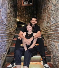 a man and woman sitting on some stairs