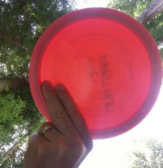 a person holding a red frisbee in their hand