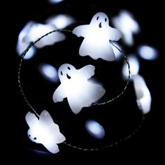 some white lights that are in the shape of ghostes on a black background,