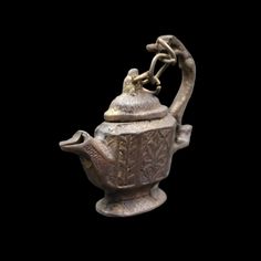 an old teapot with a bird on it