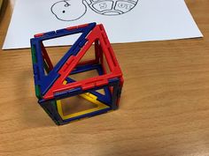 a wooden table topped with toys on top of it next to a piece of paper