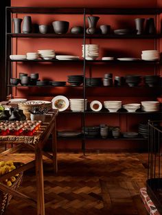 a room filled with lots of plates and bowls next to a wall full of shelves